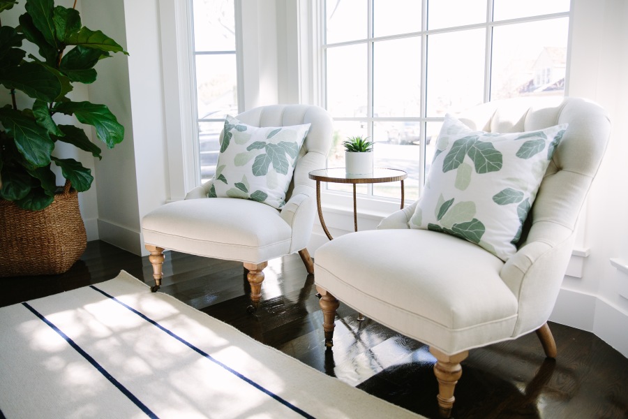 Cream chesterfield chairs with palm leaf print cushions